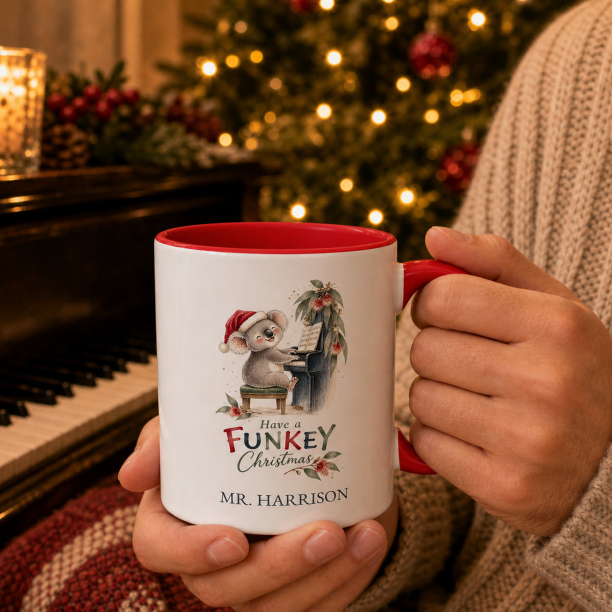 Personalised koala piano teacher Christmas mug with red handle held beside a piano