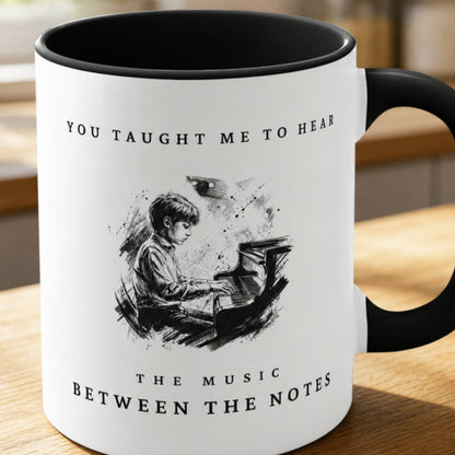 Close-up of the Between the Notes II piano teacher appreciation mug featuring expressive monochrome artwork of a young pianist at the piano with a black handle and interior.