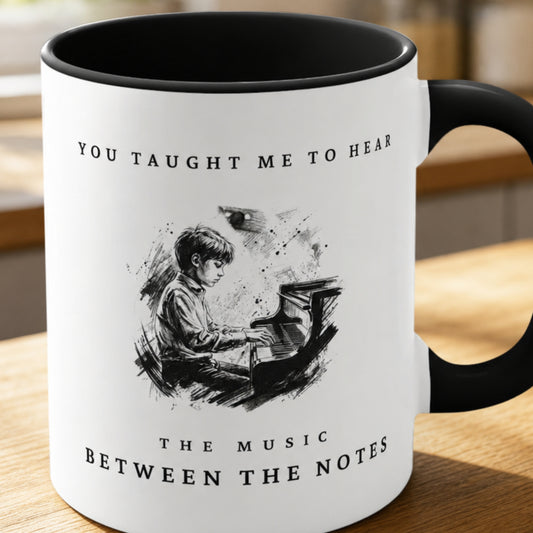 Close-up of the Between the Notes II piano teacher appreciation mug featuring expressive monochrome artwork of a young pianist at the piano with a black handle and interior.