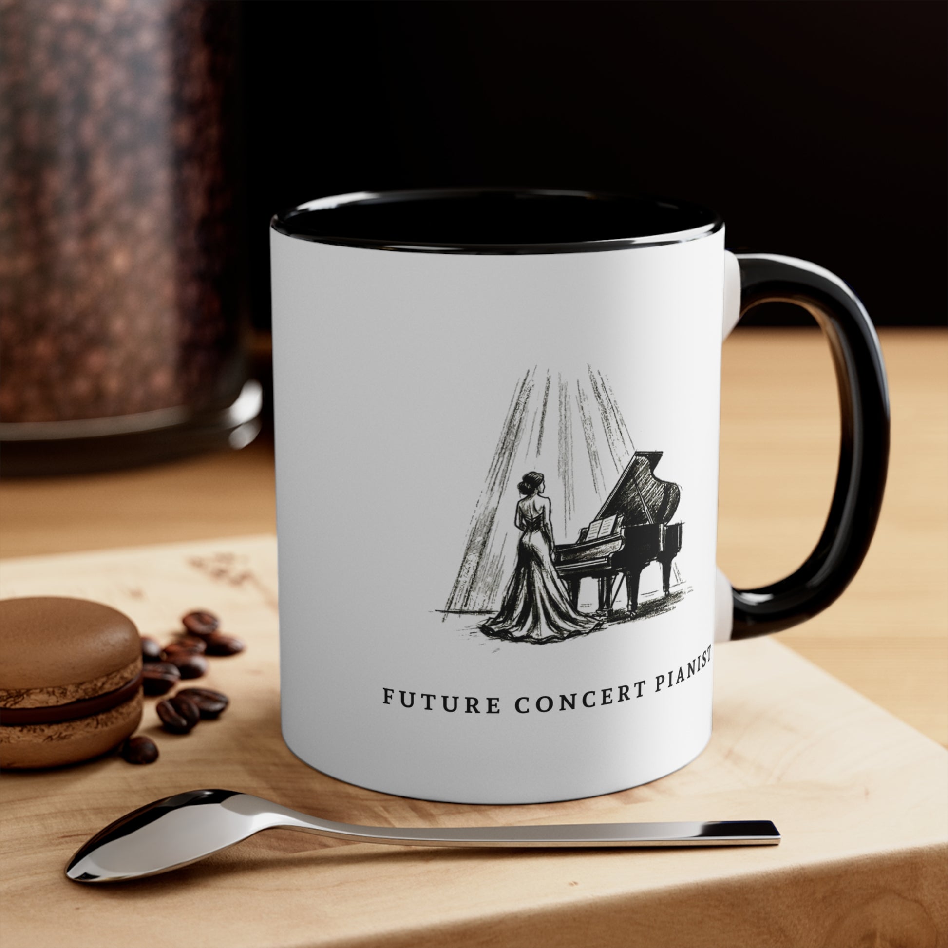 The Ovation piano mug for aspiring pianists on a wooden table beside coffee beans and a spoon with a grand piano in the background.