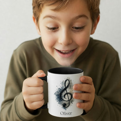 Young boy holding the personalised Treble Adventures piano mug with black handle, painterly treble clef and custom name
