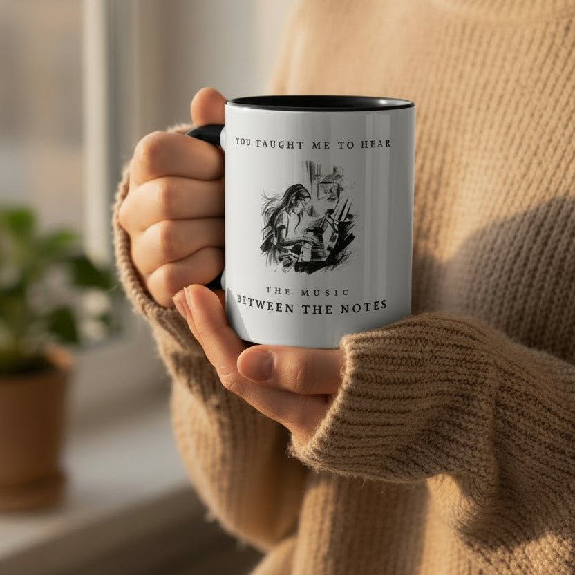 Teacher holding The Music Between the Notes piano mug while enjoying a quiet moment with a warm drink.