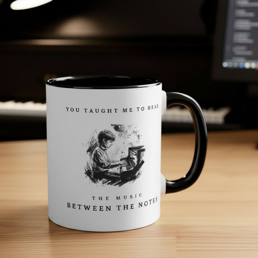 The Music Between the Notes II piano mug on a desk beside a piano and computer in a music practice workspace.