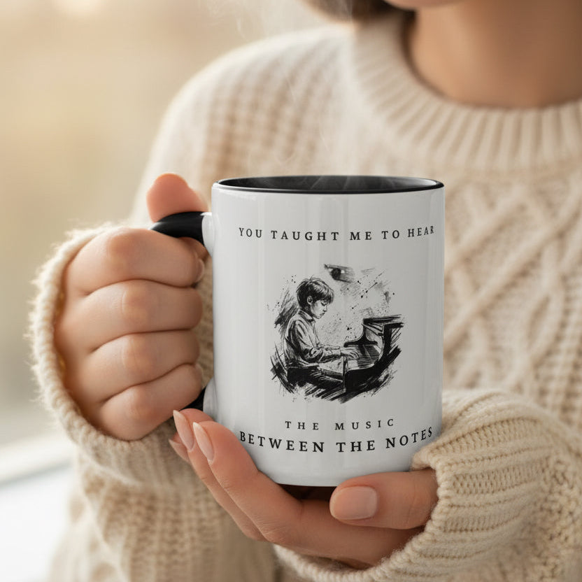 Person holding The Music Between the Notes II piano mug while enjoying a warm drink in a cosy setting.