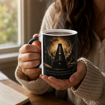 Person holding the Metronome Truths heat-reactive piano mug while enjoying a hot drink, revealing the hidden metronome artwork.