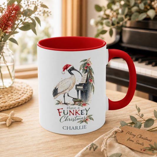 Personalised ibis piano Christmas mug with red handle beside a piano