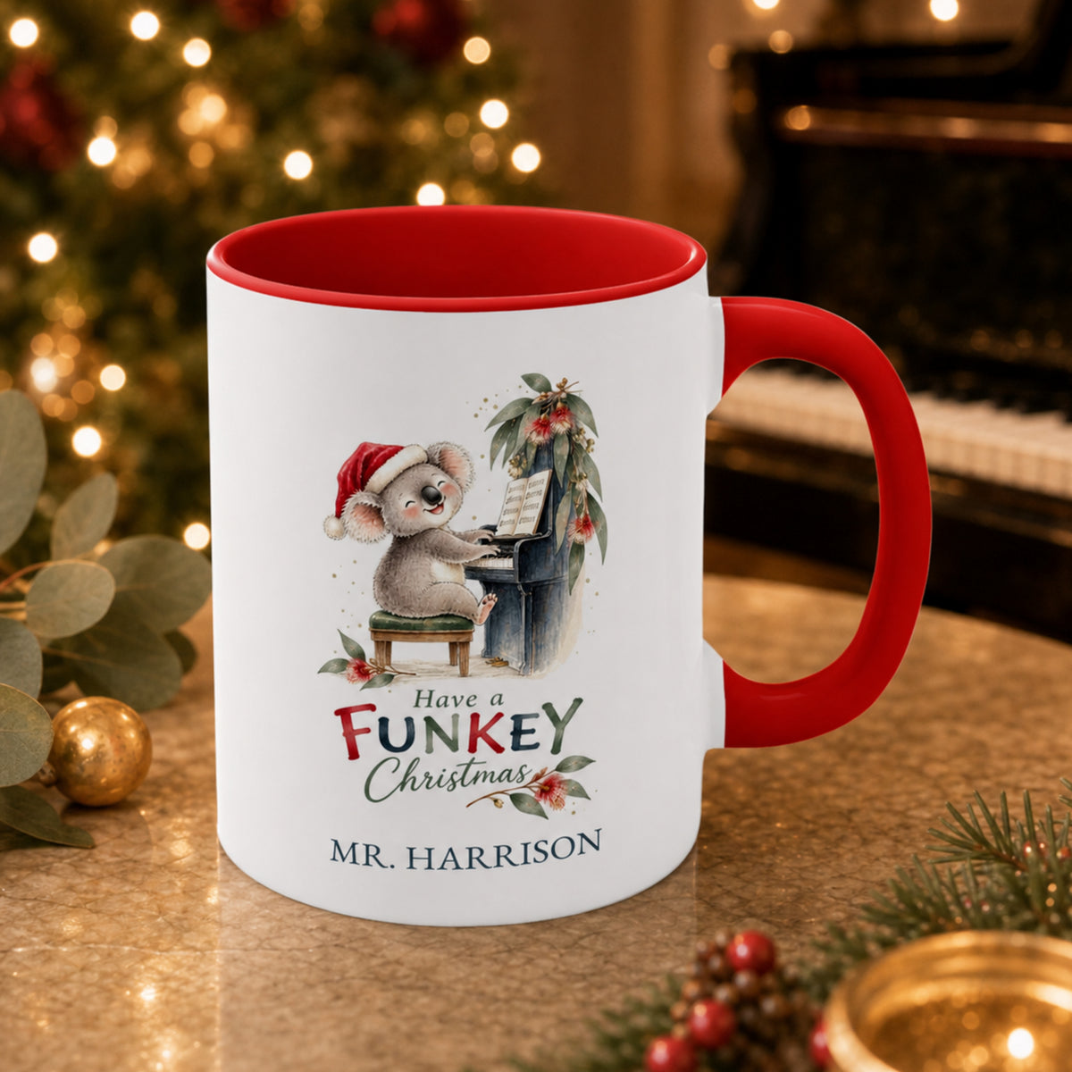 Personalised koala piano teacher Christmas mug with red handle beside a piano