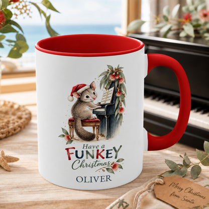 Personalised possum piano Christmas mug with red handle beside a piano